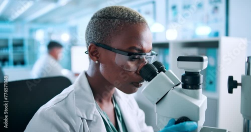 Science, research and black woman at microscope checking results in pharmaceutical test in laboratory. Glasses, safety and scientist studying sample with medical innovation for vaccine development photo