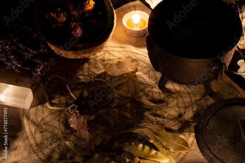 An image of a wicca altar with candles, selenite, and dried bay leaves. 