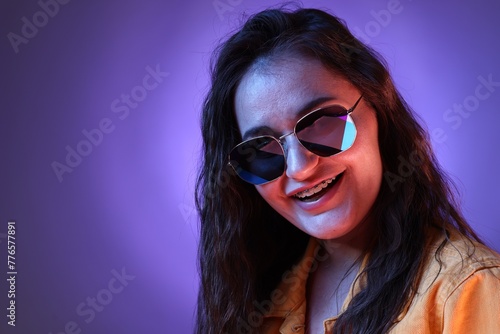 Wallpaper Mural Portrait of beautiful young woman with stylish sunglasses on color background with neon lights Torontodigital.ca