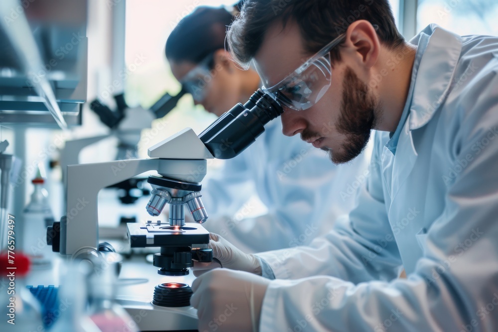 Scientists working with microscopes in a laboratory Scientists working with microscopes in a laboratory