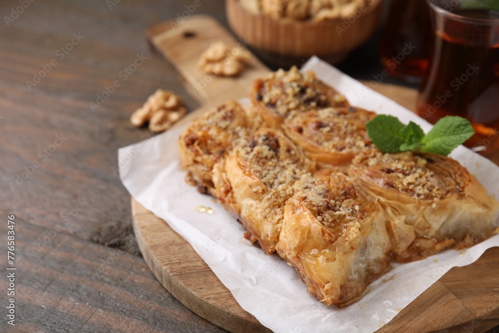 Eastern sweets. Pieces of tasty baklava on wooden table, closeup. Space for text