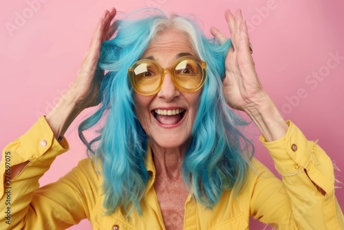 cute senior pretty woman with blue hair being happy on pink background