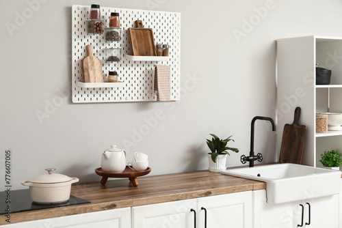 Stylish light kitchen with pegboard and kitchenware