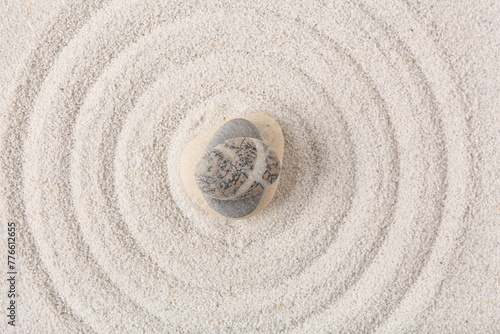 Stack of stones on sand with lines in Japanese rock garden, top view. Zen concept