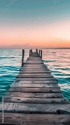 A weathered wooden pier extending into turquoise waters, disappearing into the hazy sunset © ktianngoen0128
