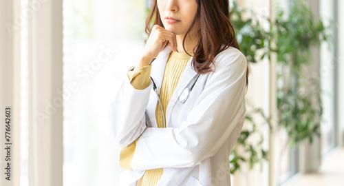 考えごとをする医療スタッフの女性 photo