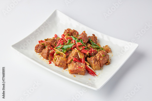 Stir-fried stewed beef shank with holy basil , chili and garlic served on white plate isolated on white background. Stir-fried holy basil is a very popular food in Thailand.