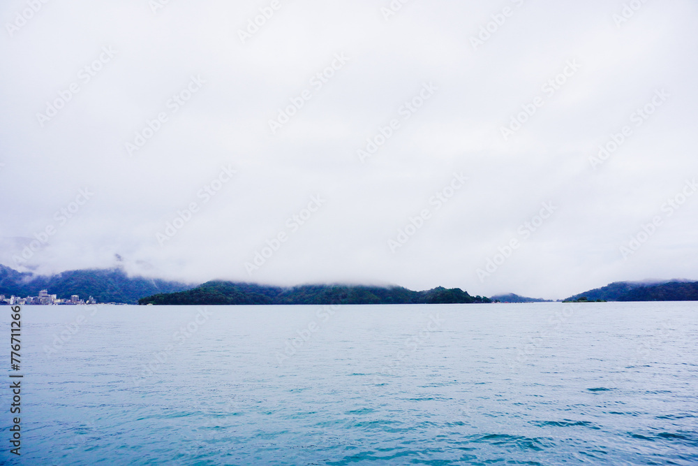 Fototapeta premium Sun Moon Lake,Nantou, Taiwan, Republic of China, 01 22 2024: The landscape of Sun Moon Lake (Ri Yue pond) in a cloudy and foggy day
