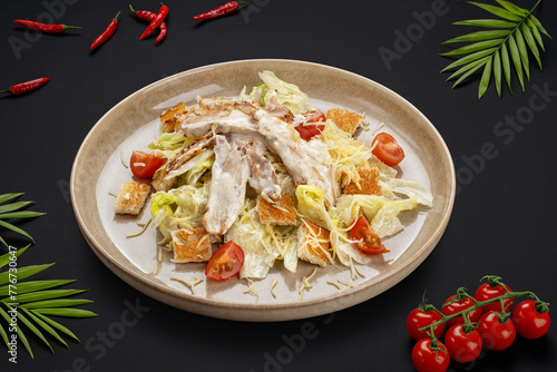Salad with chicken fillet, tomatoes, lettuce, cheese, crackers and sauce on a round plate. View from above. Food photos for cafes.