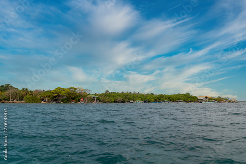 Boat on the seashore and stone spur. San Bernardo, Bolivar, Colombia.  photo