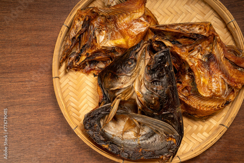 Dried fish in basket on wooden table background.