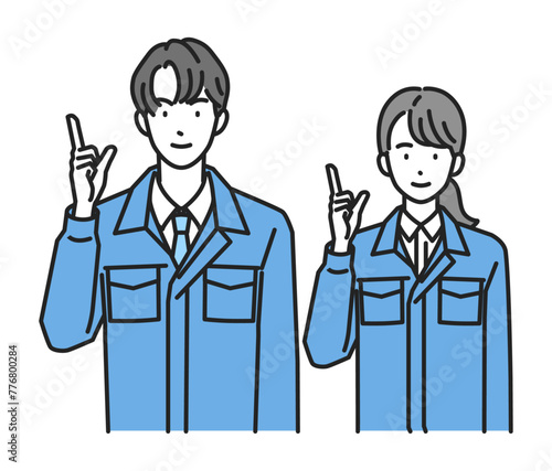 指差しポーズをする作業服姿の男性と女性（上半身）
