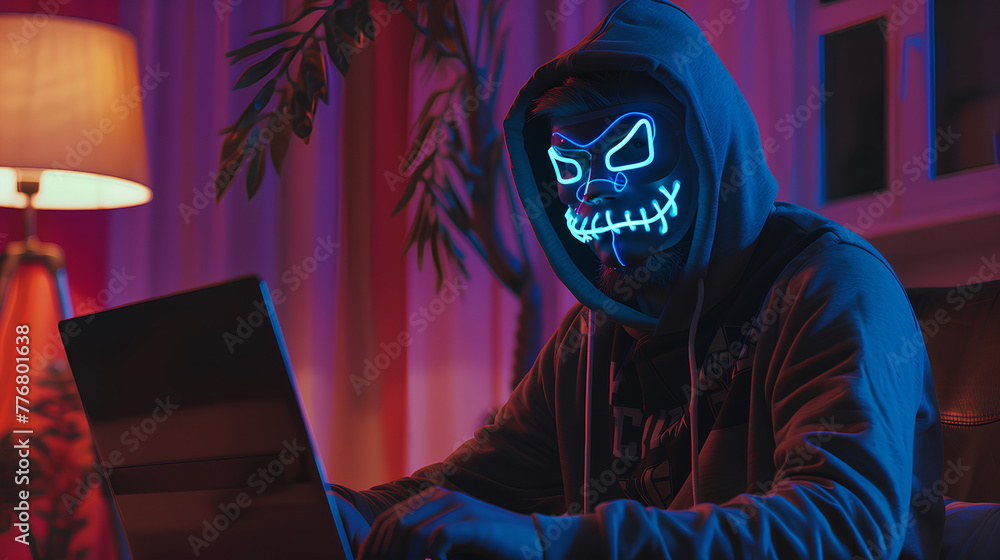 A man is wearing a hoodie and holding a laptop. The image has a dark and mysterious mood, with the man's face obscured by the hood and the laptop screen A man is wearing a hoodie and holding a laptop. The image has a dark and mysterious mood, with the man's face obscured by the hood and the laptop screen