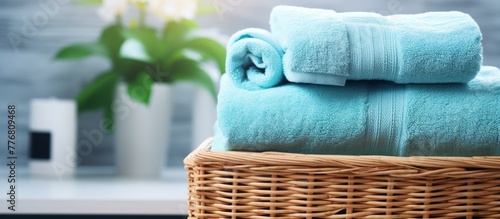 A woven basket close up shot with soft towels neatly arranged on the top