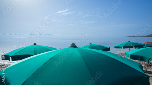 Green beach umbrella. Blue sky. Relaxing context. Summer holidays at the sea. General contest and location © Matteo Ceruti