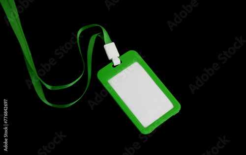 Green blank badge with string isolated on black background. 