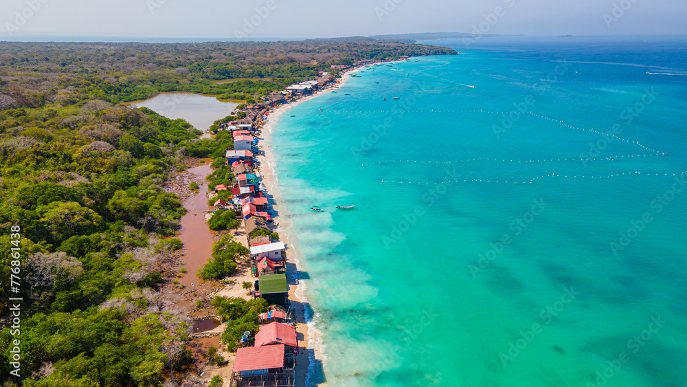Aerial view of Playa Blanca, Baru, showcasing the vibrant turquoise waters, lush greenery, and colorful beachfront properties