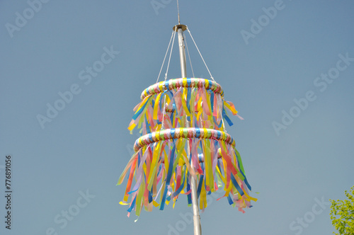 Bunte Pfingstkränze aus Tradition zum christlichen Fest: Die farbenfrohen Bändern wehen sanft im Frühlingswind vor blauen Himmel.
