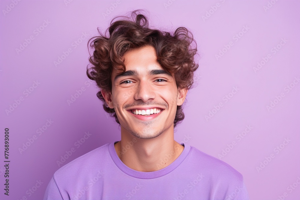 A man with curly hair is smiling and wearing a purple shirt A man with curly hair is smiling and wearing a purple shirt