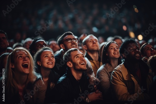 A crowd of people are watching a show, with some of them smiling and laughing