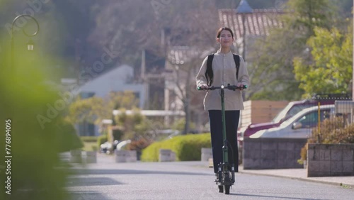 住宅街を電動キックボードで移動する日本人の女性