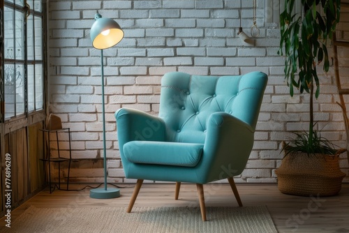 Bright turquoise armchair in a Scandinavian-style room with matching floor lamp  next to a white brick wall and potted plant