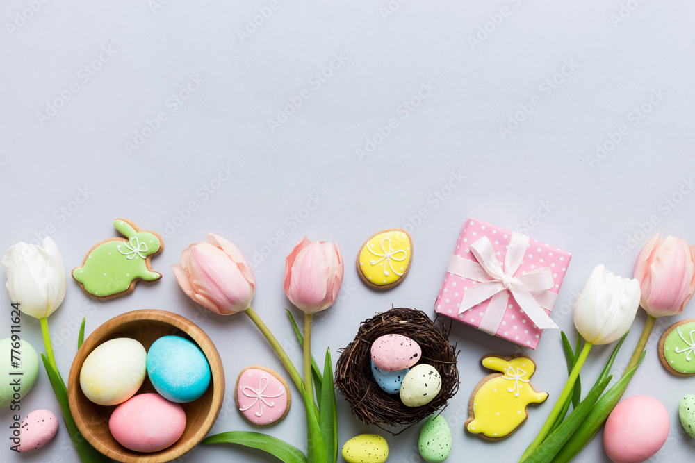 Easter frame with eggs, gift box and tulip on a colored background. The minimal concept. Top view Happy Easter composition. Card with a copy space of the place for the text Easter frame with eggs, gift box and tulip on a colored background. The minimal concept. Top view Happy Easter composition. Card with a copy space of the place for the text