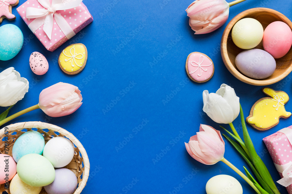 Easter frame with eggs, gift box and tulip on a colored background. The minimal concept. Top view Happy Easter composition. Card with a copy space of the place for the text Easter frame with eggs, gift box and tulip on a colored background. The minimal concept. Top view Happy Easter composition. Card with a copy space of the place for the text