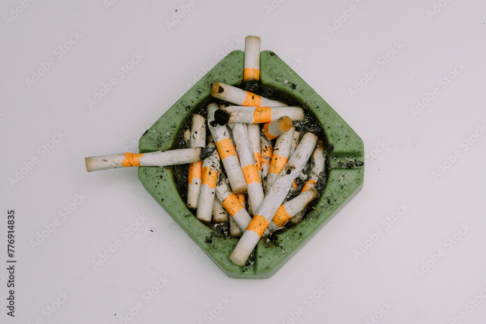 Cigarette butts and ashtrays used by people smoking were placed on white mats Cigarette butts and ashtrays used by people smoking were placed on white mats