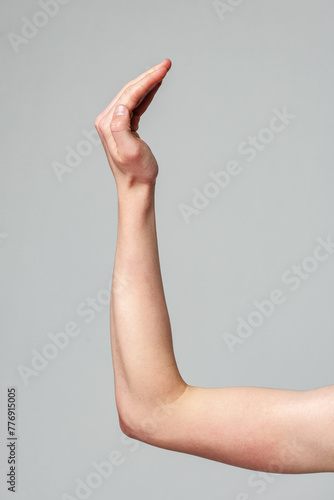 Human Hand Raised Against a Neutral Gray Background in a Studio Setting