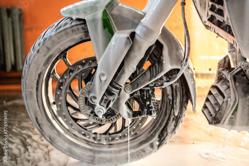 Motorcycle wheel cleaning with foam photo