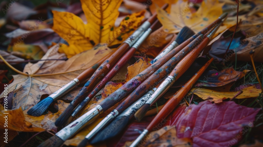 Fototapeta premium A pile of paintbrushes on a leafy ground