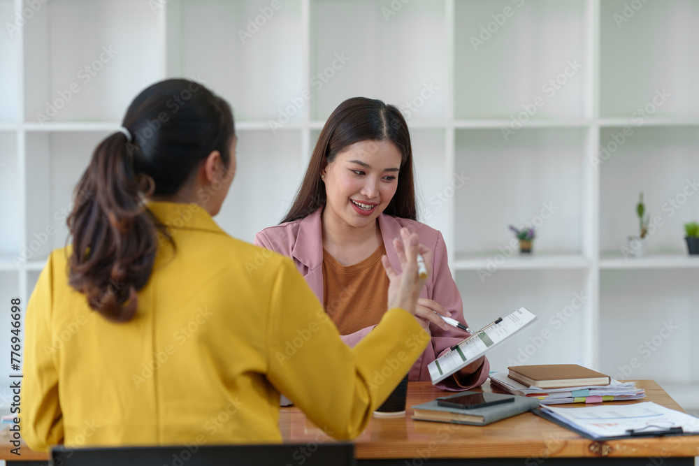 Two Young Asian businesswoman discuss with new startup project Idea presentation, analyze planning and financial statistics and investment market at office. Two Young Asian businesswoman discuss with new startup project Idea presentation, analyze planning and financial statistics and investment market at office.