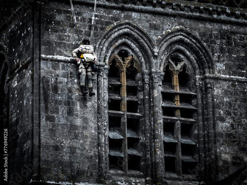 Second world war commemoration at SAINTE MERE L'EGLISE In Normandy, FRANCE. Armed fake soldier with parachute hanged bell tower church