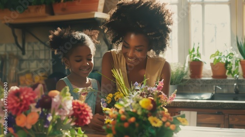 A Young African American woman and daughter having fun arranging flowers in the kitchen Teaching children in flower arranging, craftsmanship