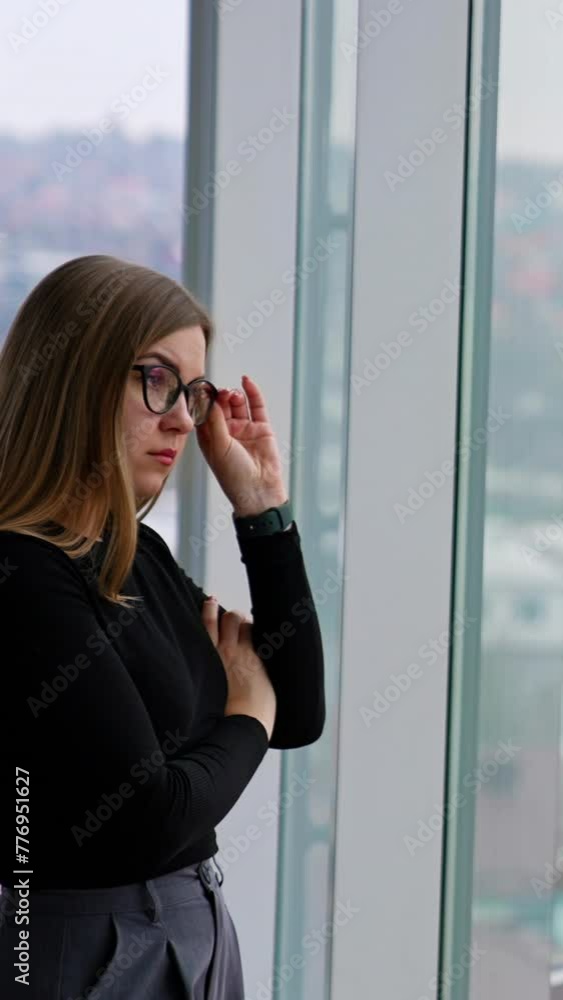 woman in eyeglasses while standing by the window Vertical video woman in eyeglasses while standing by the window Vertical video