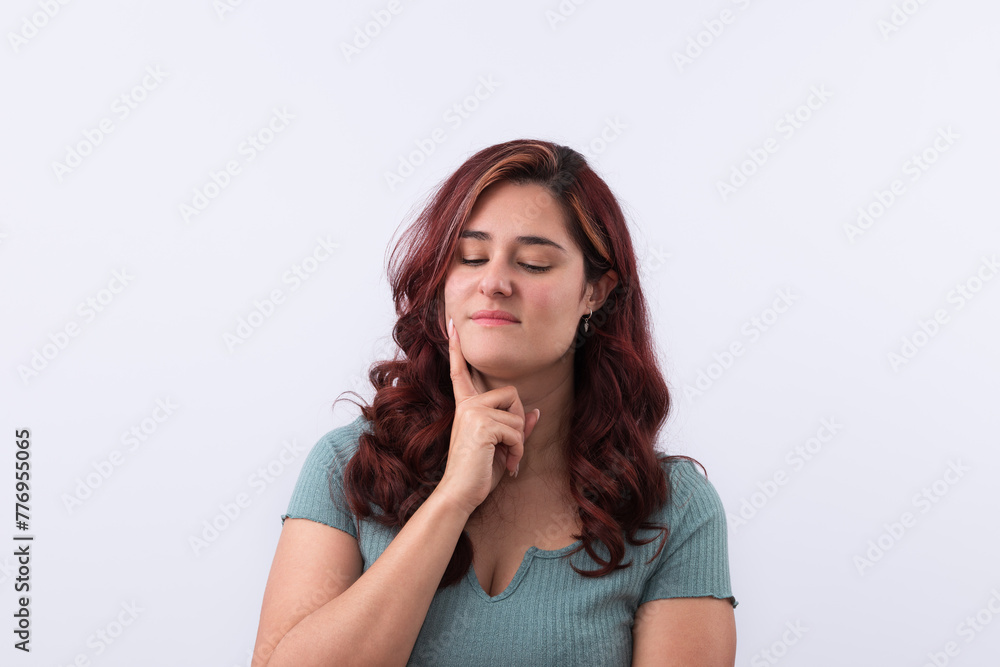 Horizontal portrait of a pensive young woman with her hand resting on her face with reflective gesture looking down. Light background and copy space. Promotion and marketing concept Horizontal portrait of a pensive young woman with her hand resting on her face with reflective gesture looking down. Light background and copy space. Promotion and marketing concept
