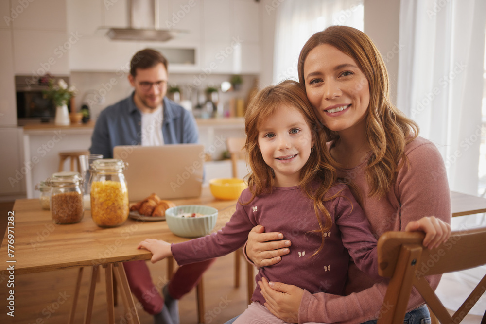 Happy family playing over breakfast at table in kitchen Happy family playing over breakfast at table in kitchen