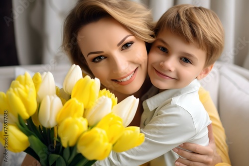 Close-up of a smiling woman and boy with vibrant yellow and white tulips.