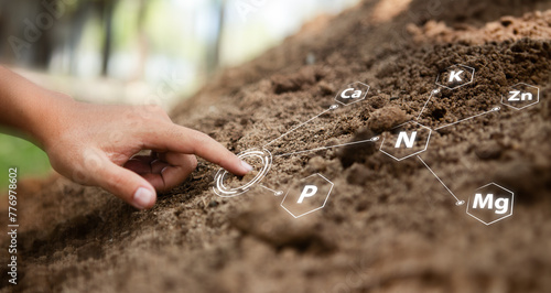 Hand pointing at minerals in the soil or nutrients of the ground around are fertile and fertilized. Bathed in warm sunlight, suitable for planting crops and growing sustainable agriculture farming. photo