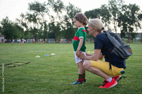 Mom with her son on the soccer field. A parent cares and encourages his child.