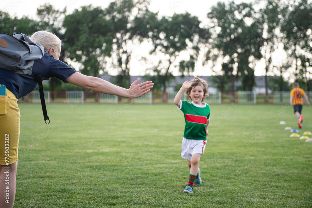 Mom with her son on the soccer field. A parent cares and encourages his child.