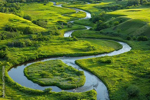 Aerial view of a winding river through green fields