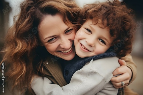 Radiant smiles fill the frame as a mother hugs her curly-haired son in a joyful moment.