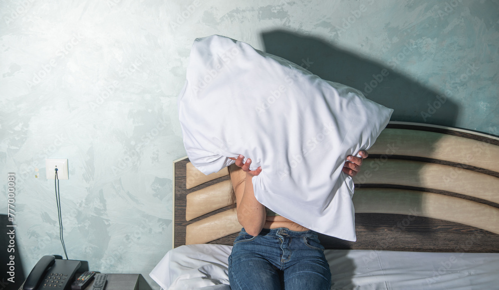 Caucasian young woman holding pillow on a bed. Caucasian young woman holding pillow on a bed.