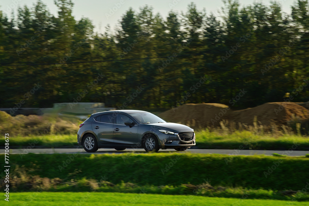 Journey Through Nature in a Sleek Vehicle Amidst Golden Grasslands