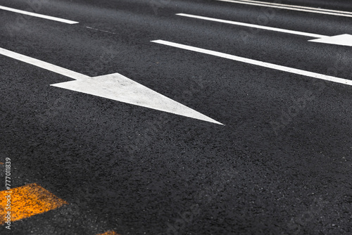 White arrows and lines, road marking on dark highway asphalt photo