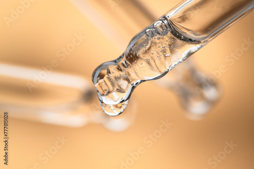 Cosmetic droppers with serum, peptide with bubbles for body care on a beige background, close-up. Beauty background