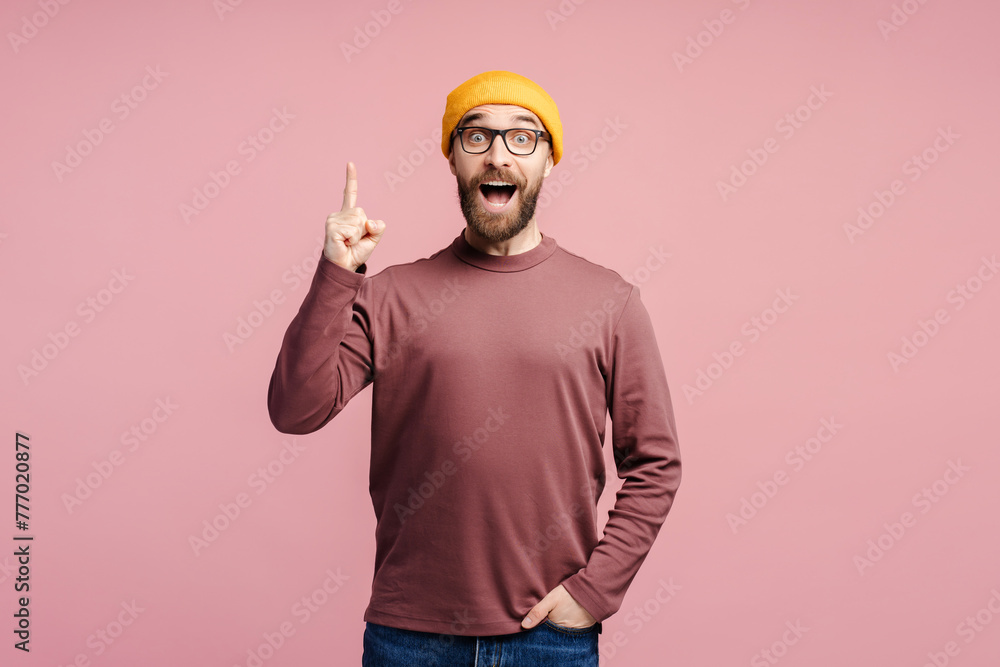 Amazed man adult wearing stylish eyeglasses, pointing index finger up