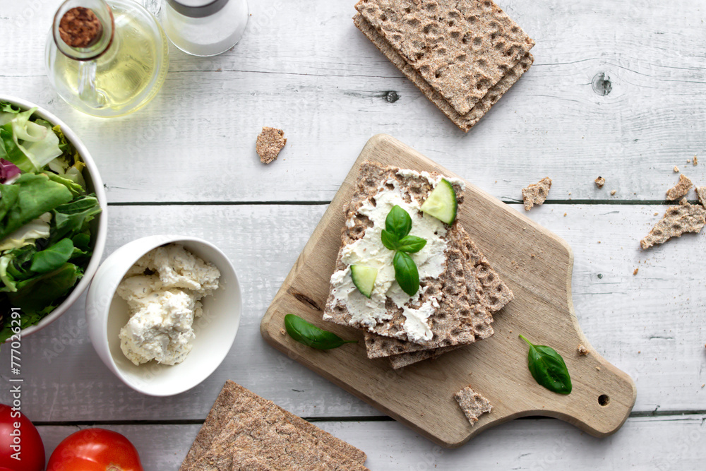 healthy crispy wheat bread with cheese, cucumber on a wooden background. breakfast healthy crispy wheat bread with cheese, cucumber on a wooden background. breakfast